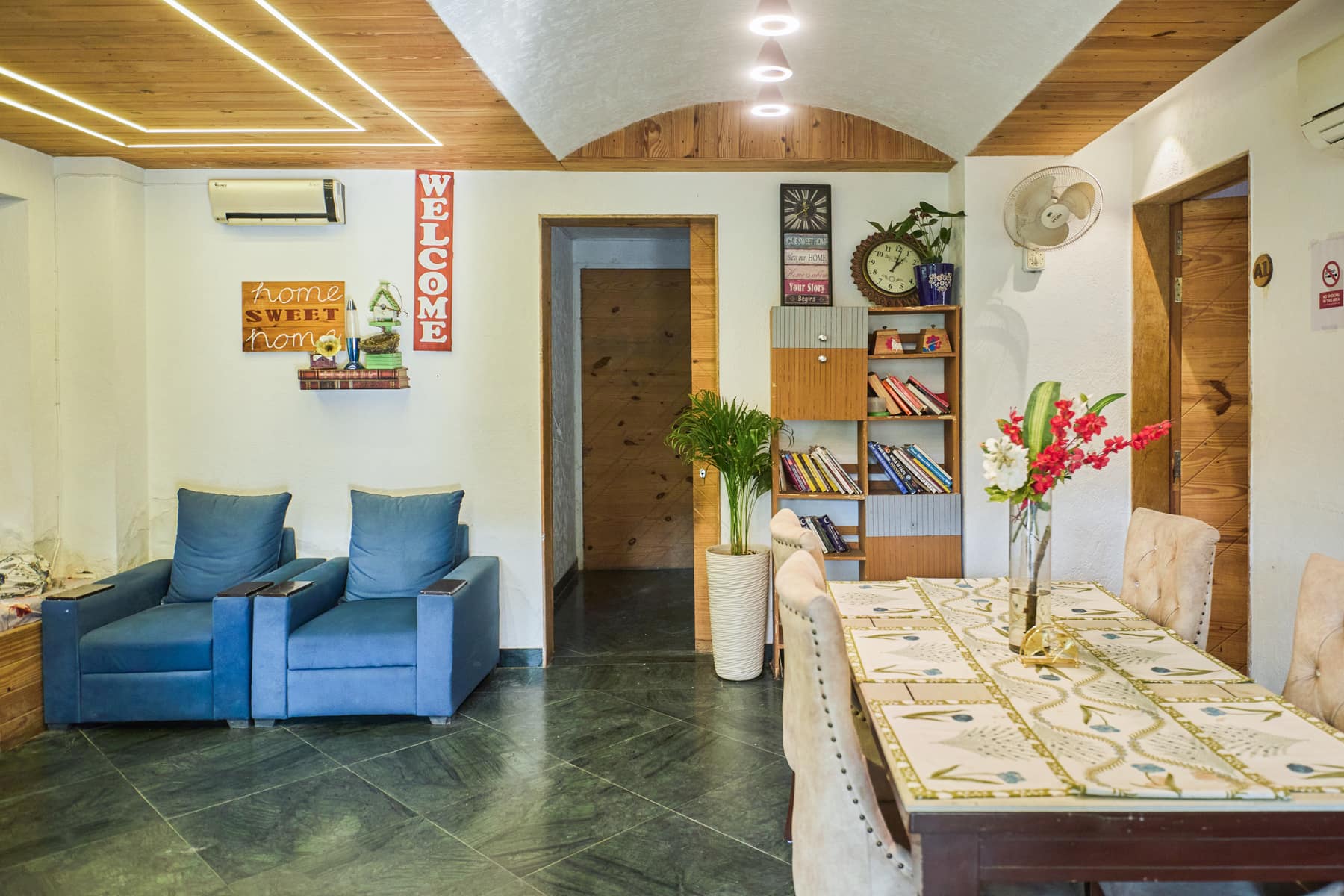 Cottage lounge with blue armchairs, bookshelf and dining table
