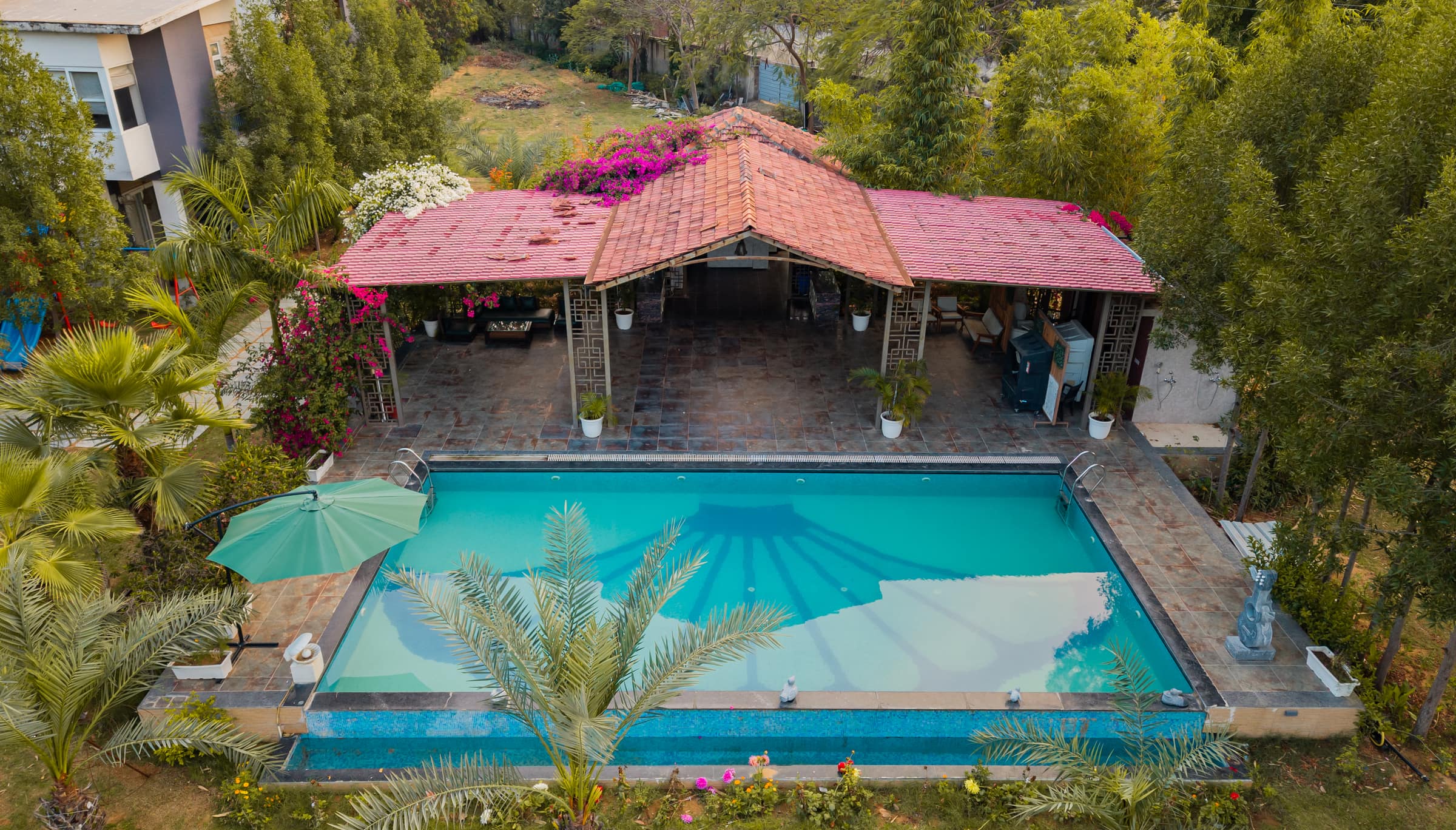 The Oasis Pool from the air, with its tiled pavilion, bougainvillea and date palms alongside
