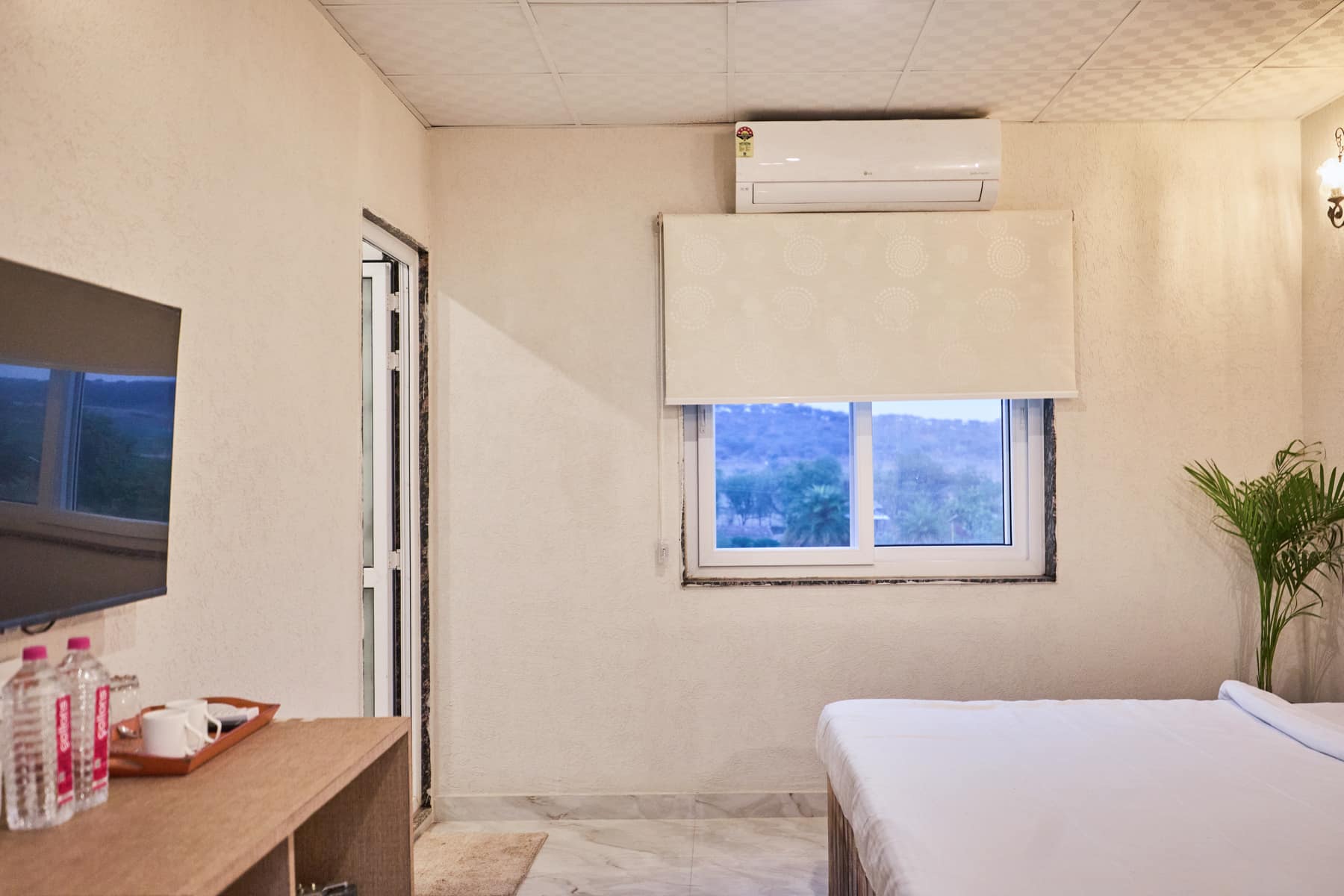 Bedroom window framing the Aravalli hills at dusk